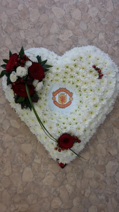 Manchester Unite Heart tribute - A beautiful red rose heart tribute with Manchester United in the Centre. Call us for more information on T: 01948 661111 for more information on this product for sizes,  flowers and prices. 

15 " Start from £90.00

18" Start from £120.00

21" Start from £150.00 

Please choose the amount for the size you wish the product to be.