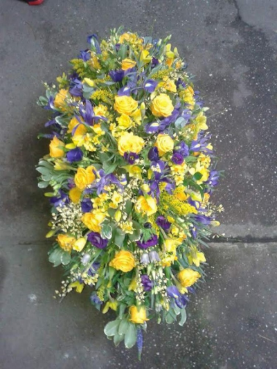 Yellow and purple Coffin Spray - This coffin spray has beautiful yellow and purple roses and purple delphinums with filler and greenary. Please call us on T:01948 661111 for more information on this funeral product. 

3FT Sprays start from £150.00

4FT Sprays start from £250.00

5FT Sprays start from £450.00.

Please choose the amount for the size you wish the product to be.