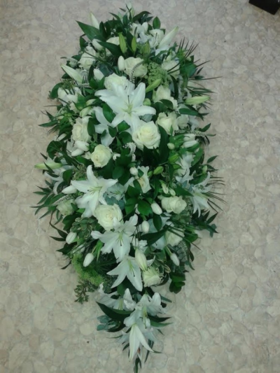 White Lily and Cream Rose Coffin Spray - This coffin spray has beautiful white lilys and Cream roses with filler and greenary. Please call us on T:01948 661111 for more information on this funeral product. 

3FT Sprays start from £200.00

4FT Sprays start from £350.00

5FT Sprays start from £550.00.

Please choose the amount for the size you wish the product to be.